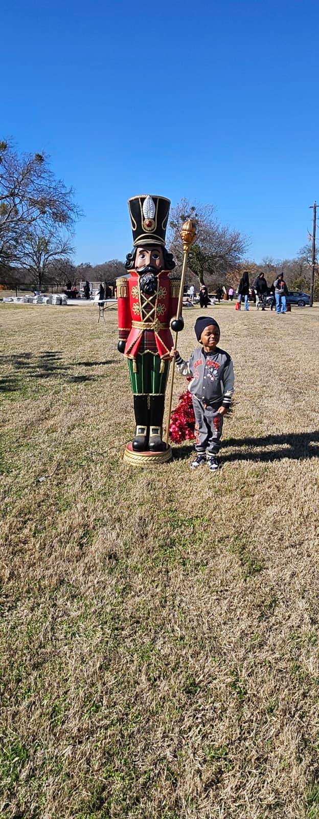 A young guest posing with the nutcracker on the lawn