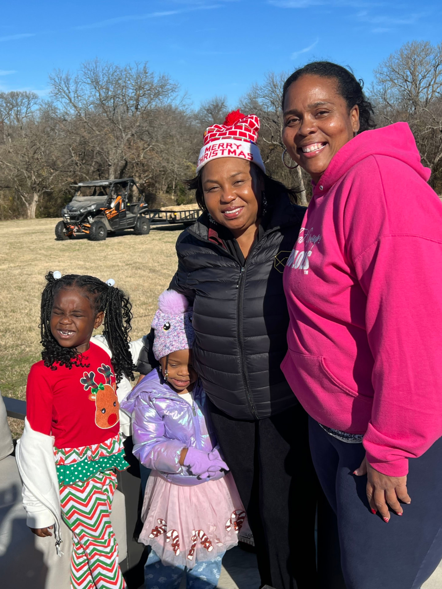 Tara with a family in Christmas hats on the lawn